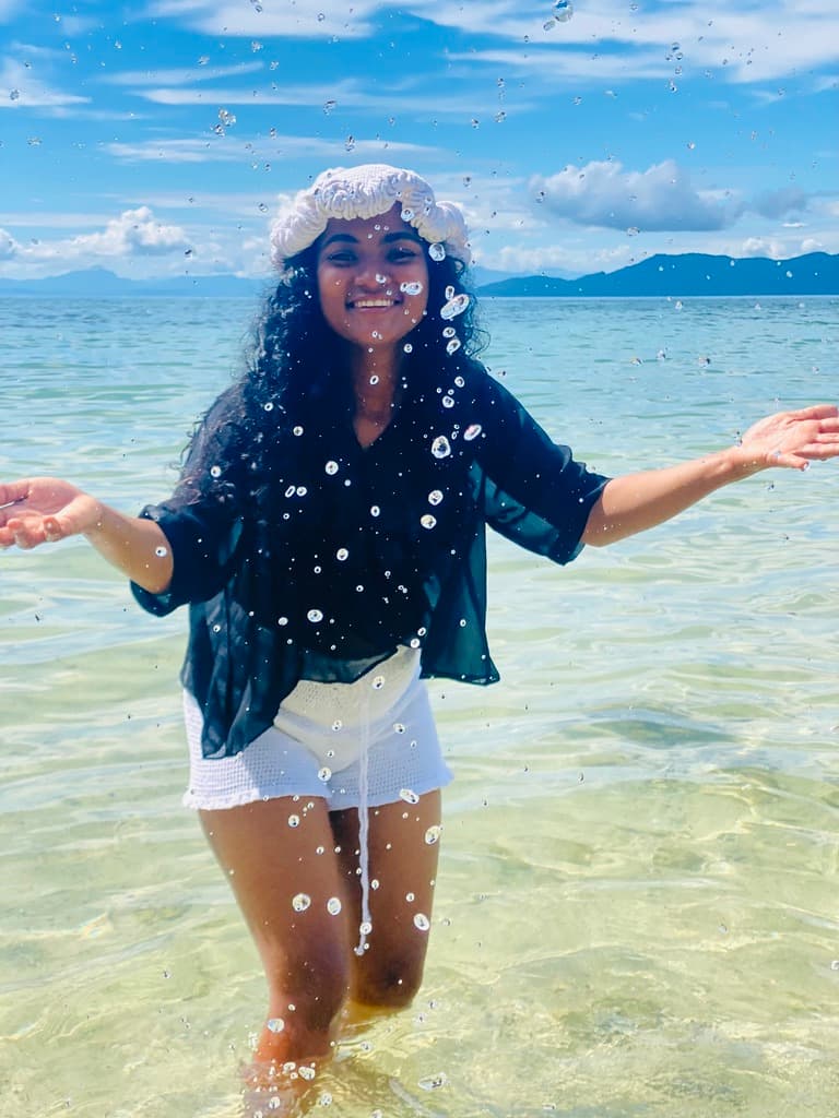 Créatrice Art Jatie posant en tenue crochet sur la plage à Madagascar